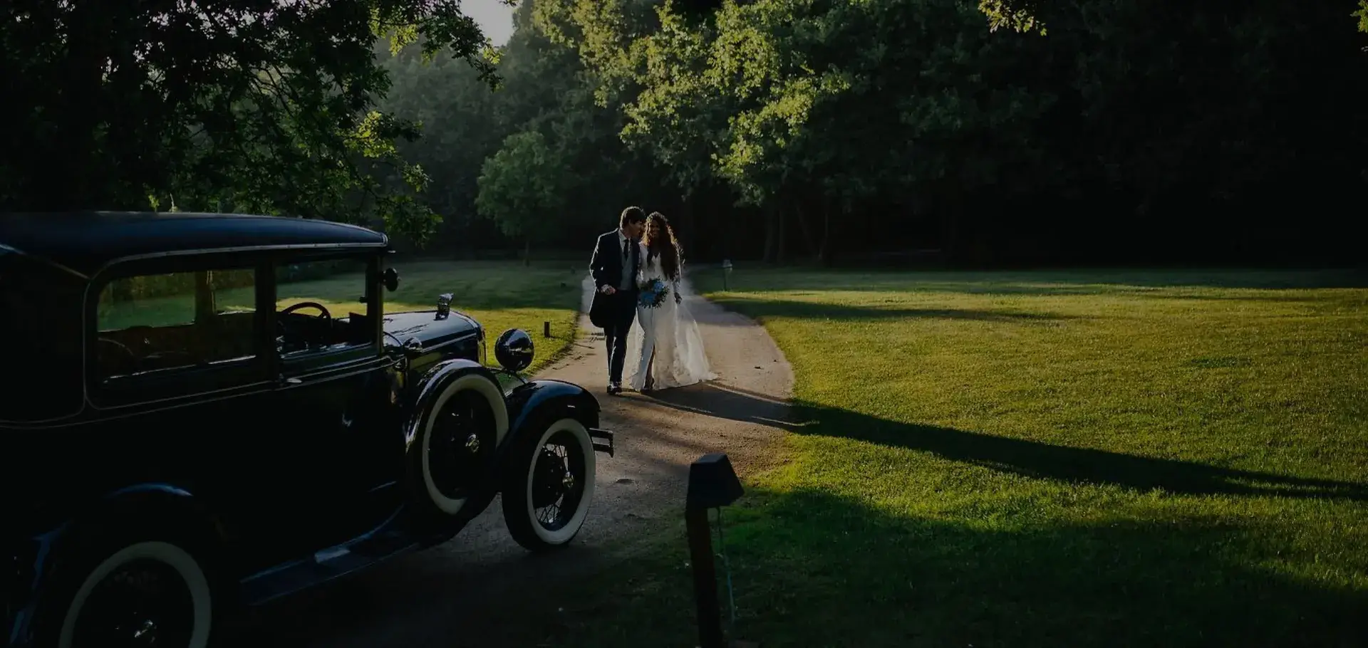 Coche antiguo y pareja de novios caminando por el Pazo de Cea